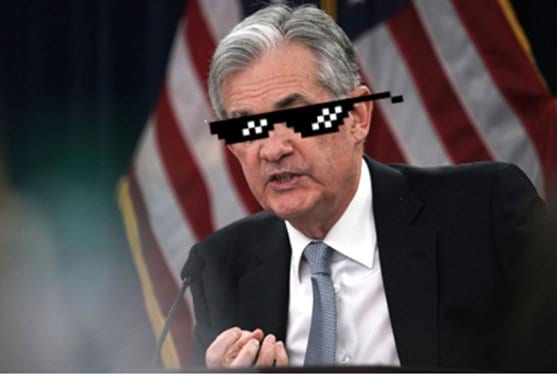 Man in a suit speaking at a microphone, edited with pixelated meme sunglasses